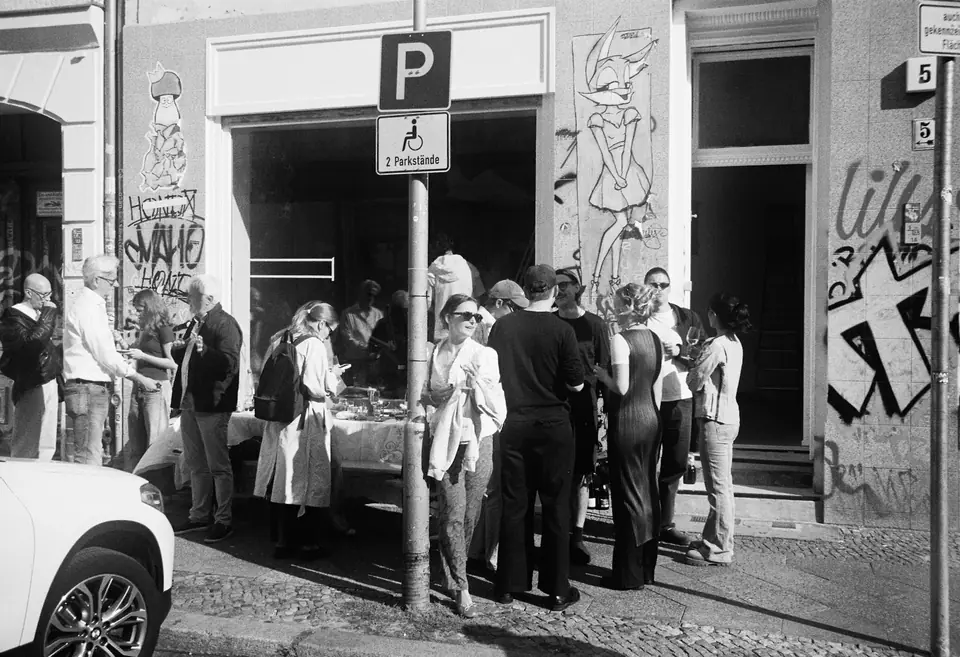 Black-and-white photograph of visitors gathered on the pavement outside the studio at Eisenbahnstraße 5